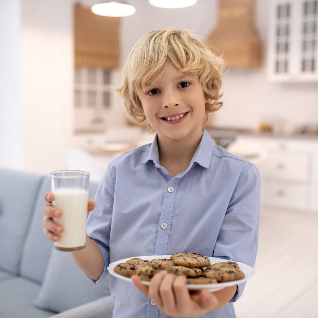 Boy Holding a glass of milk and cookies